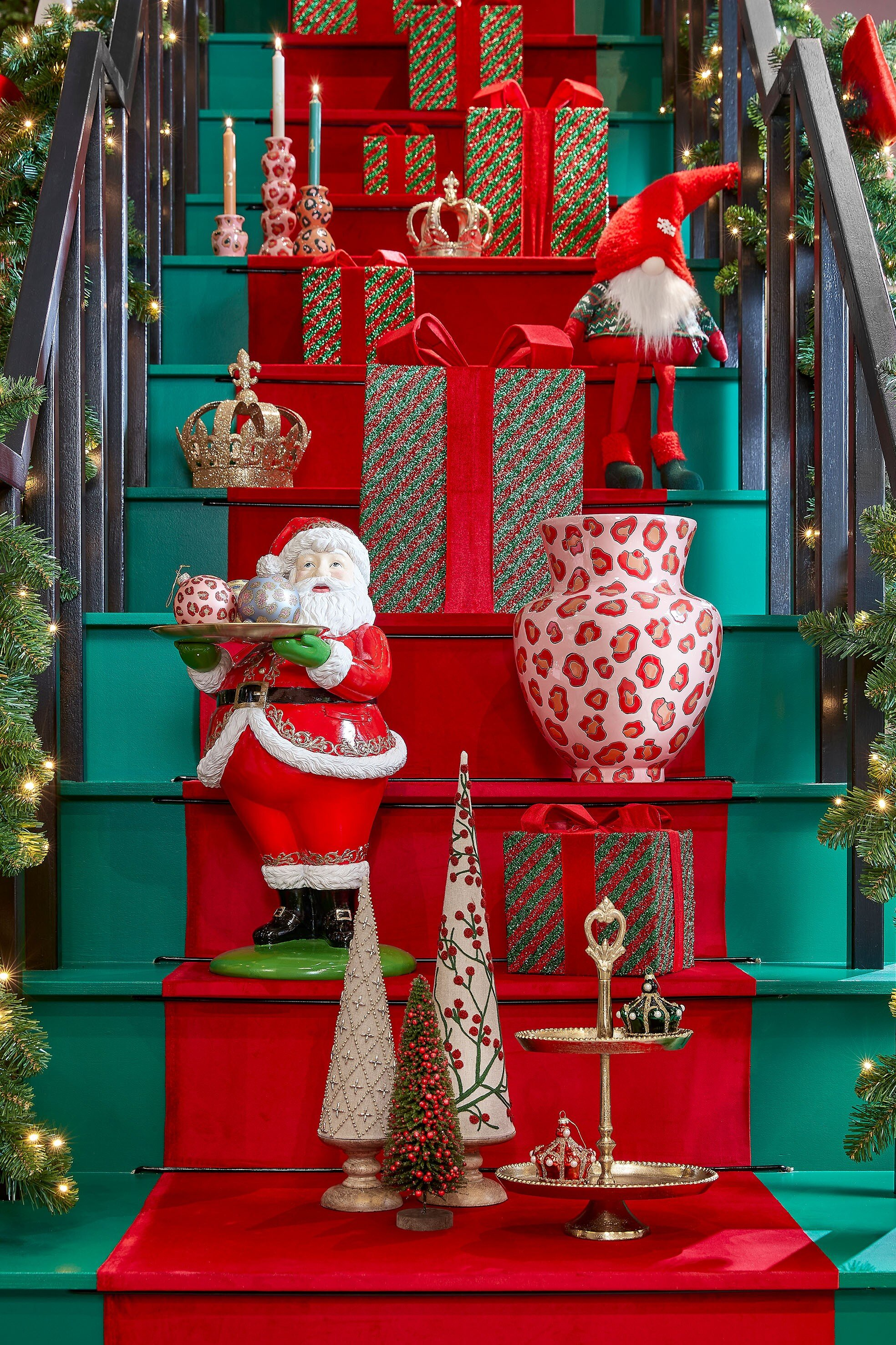 Escalier festif décoré avec des cadeaux de Noël, des ornements, une figurine du Père Noël et un gnome.