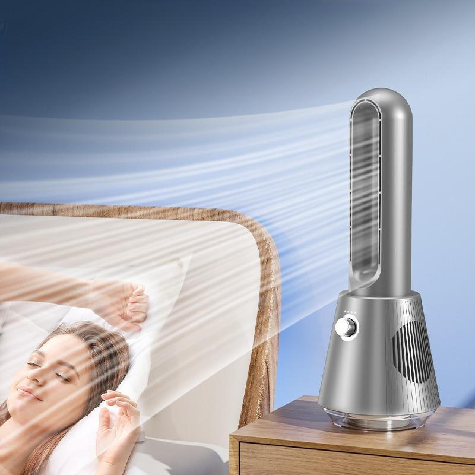 Eine Frau schläft in der Nähe eines Ventilators, der Luft bläst. Der Ventilator ist silberfarben und steht auf einem Holztisch.
