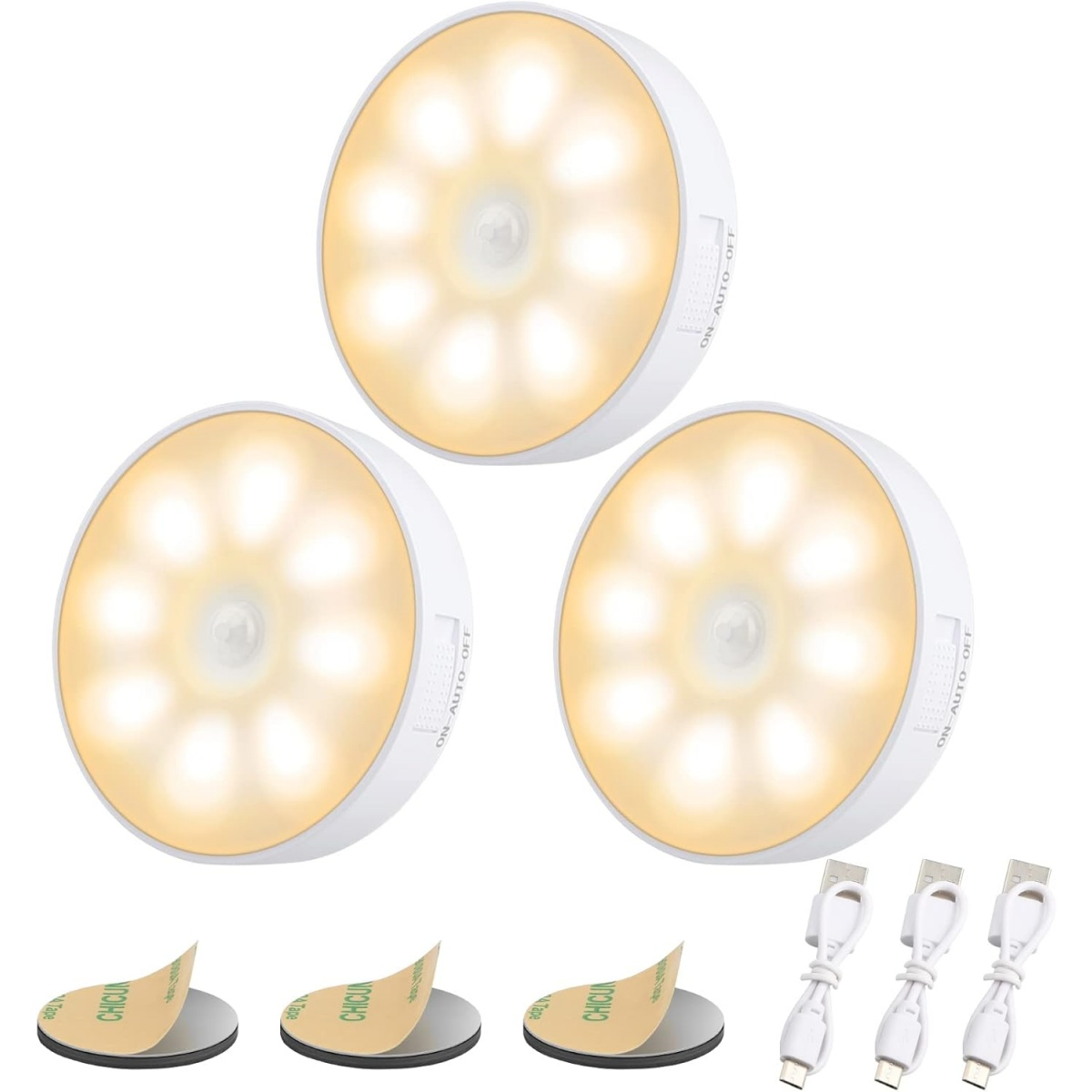 Tre luci LED bianche con cuscinetti adesivi e cavi di ricarica. Le luci sono rotonde con un bagliore giallo e un interruttore on-off.