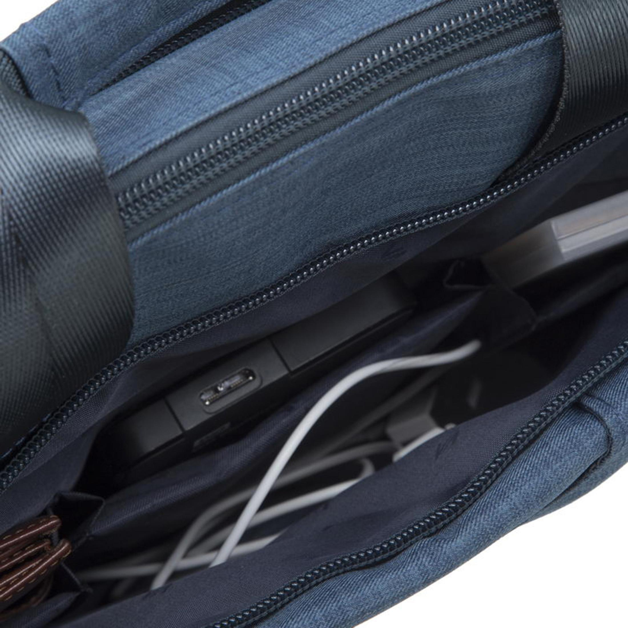 All'interno di una borsa di jeans blu. Un telefono, cavi e altri oggetti sono all'interno. Una cerniera è in alto.