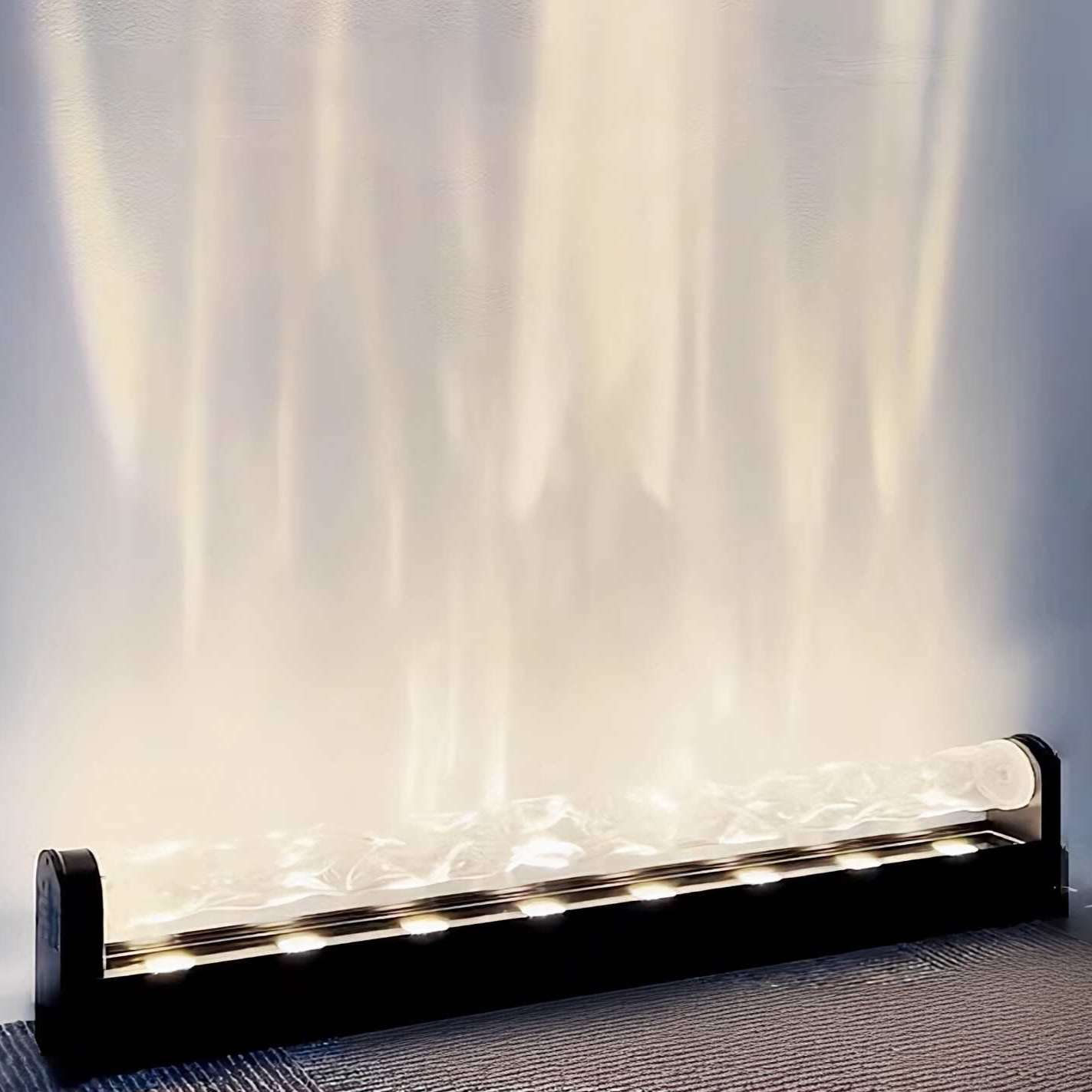 Eine moderne schwarze Leuchte mit transluzenter, strukturierter Abdeckung strahlt helles Licht aus und wirft Schatten an die Wand.