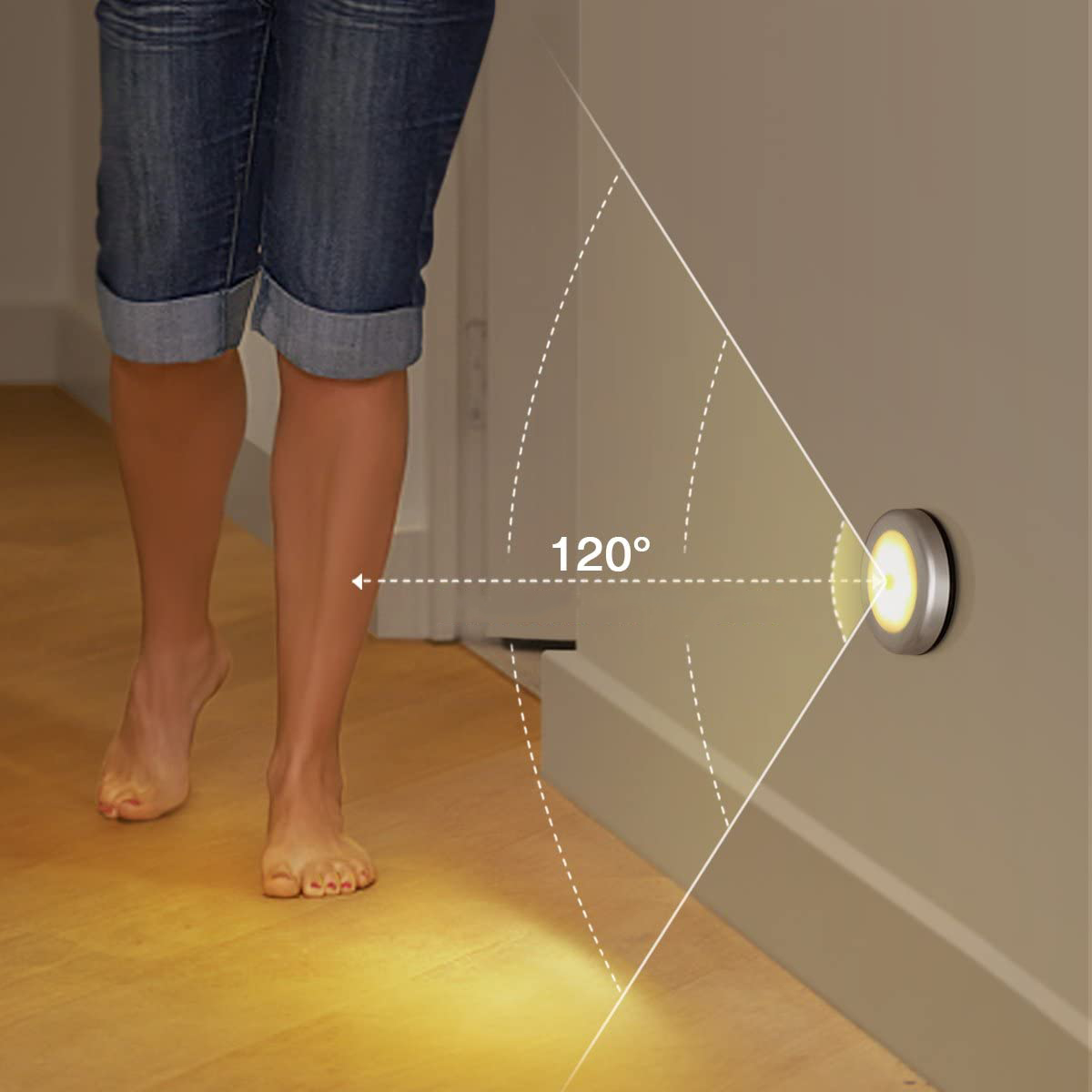 Eine Person geht barfuß auf eine Wand mit einem beleuchteten kreisförmigen Licht zu. Das Licht scheint in einem Winkel von 120 Grad. Sie trägt Jeansshorts.