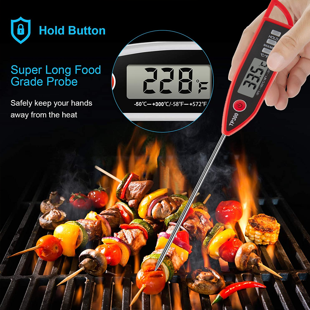 Ein Lebensmitteltemperaturmessgerät misst 335°F. Spieße mit gegrilltem Gemüse und Fleisch liegen auf einem Grill mit Flammen im Hintergrund.