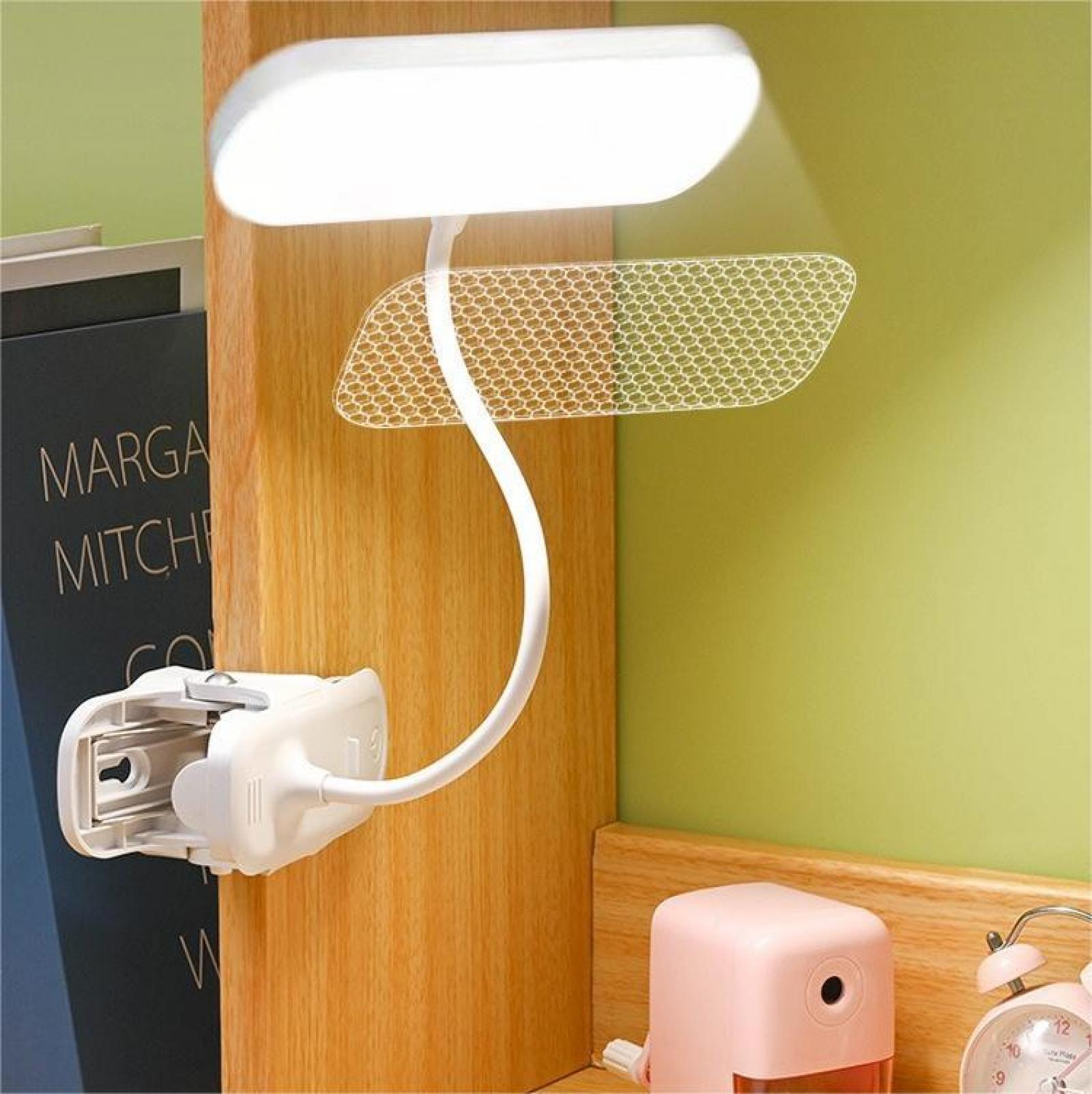 Eine weiße LED-Lampe ist an einer Holzoberfläche befestigt. Auf der rechten Seite befinden sich ein rosa quadratisches Objekt und eine Uhr.