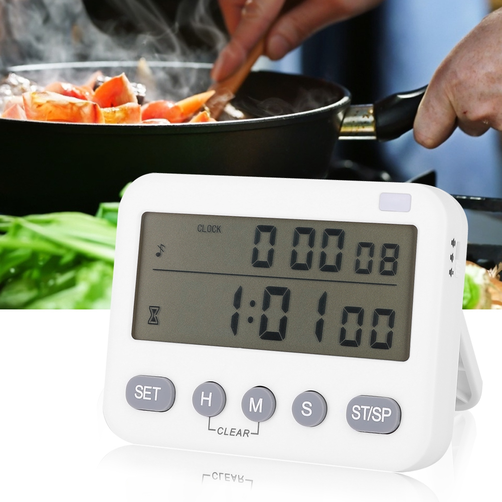 Ein weißer Timer zeigt 0:00:08 und 1:01:00 an. Im Hintergrund rührt eine Person Essen in einer Pfanne. Gemüse und Dampf sind sichtbar.