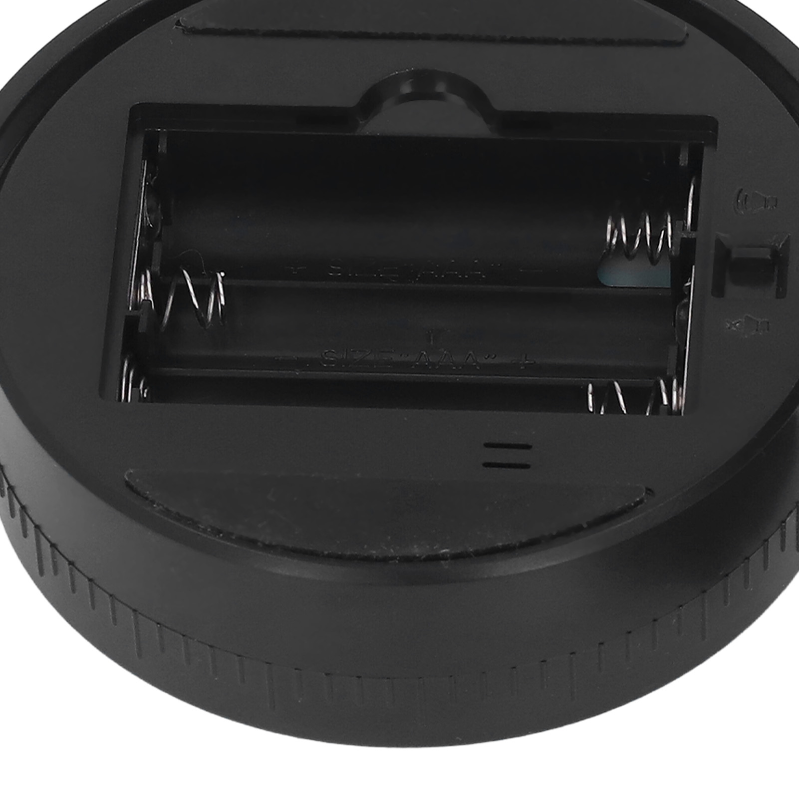 Nahaufnahme eines schwarzen Batteriefachs. Zwei AAA-Batterie-Steckplätze mit Federn sind sichtbar. Der Sockel ist rund.