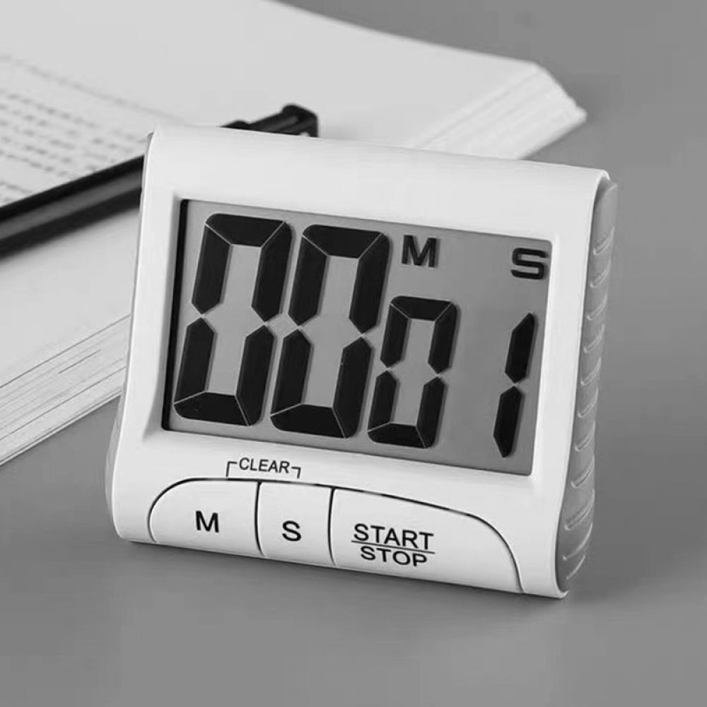 Ein weißer Timer zeigt 00:01 an. Er hat Tasten für Minuten (M), Sekunden (S) und Start/Stopp. Im Hintergrund sind Stift und Papier.