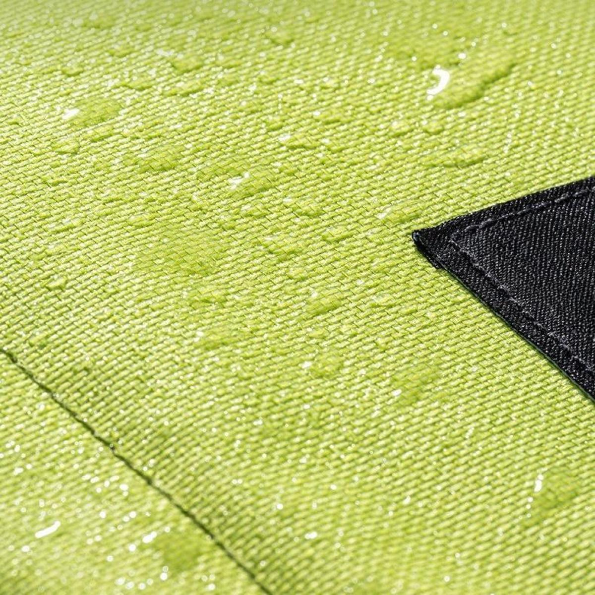 Nahaufnahme eines limettengrünen Stoffes mit Wassertropfen. Ein schwarzes Dreieck befindet sich in der Ecke. Diagonale Nähte sind sichtbar.