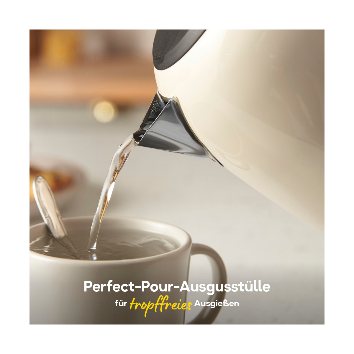 Ein weißer Wasserkocher gießt Wasser in eine Tasse mit Löffel. Text: 'Perfect-Pour-Ausgusstütte für tropffreies Ausgießen'.