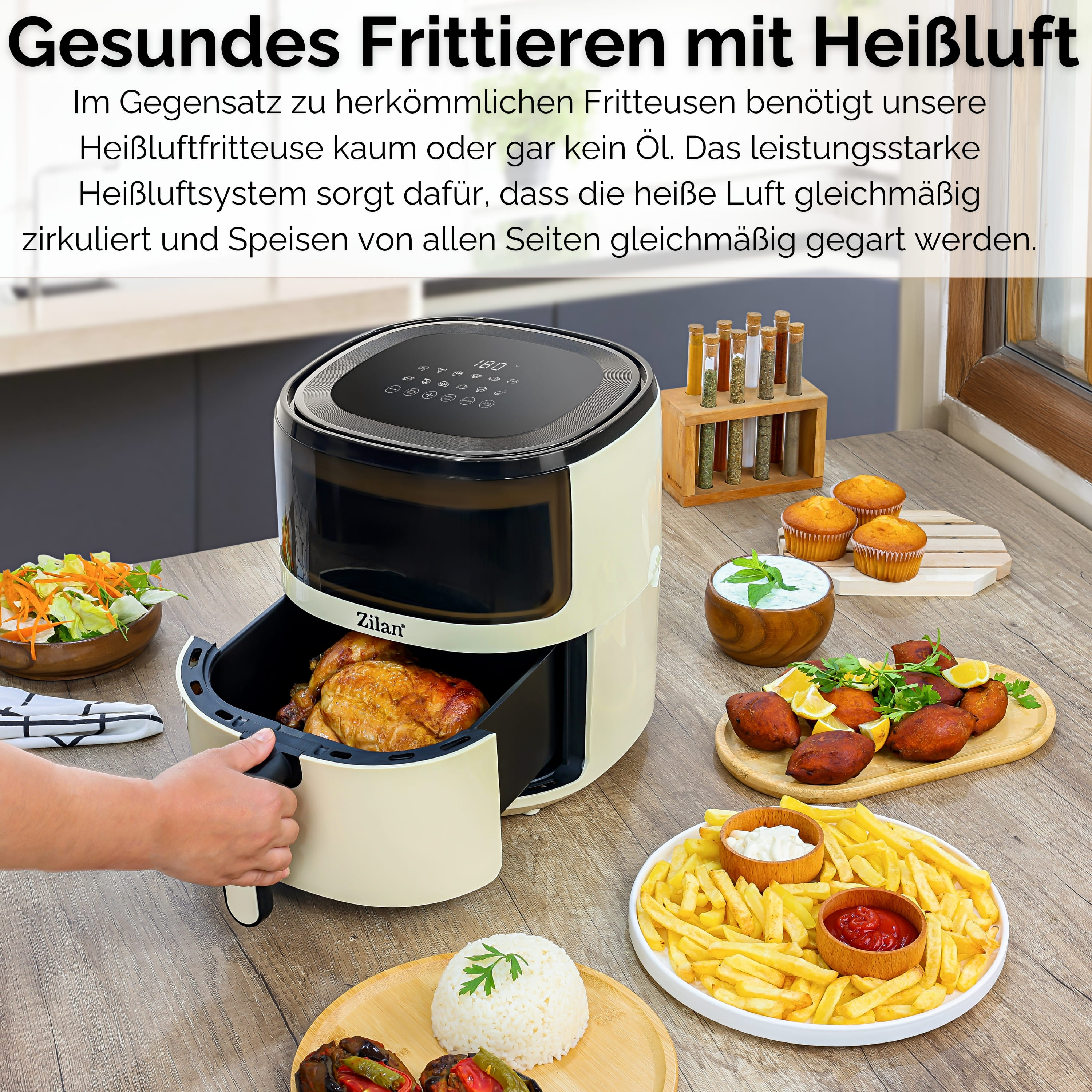 Eine Heißluftfritteuse mit Essen auf einem Holztisch. Eine Hand öffnet die Fritteuse. Es gibt Pommes, Reis und andere Speisen.
