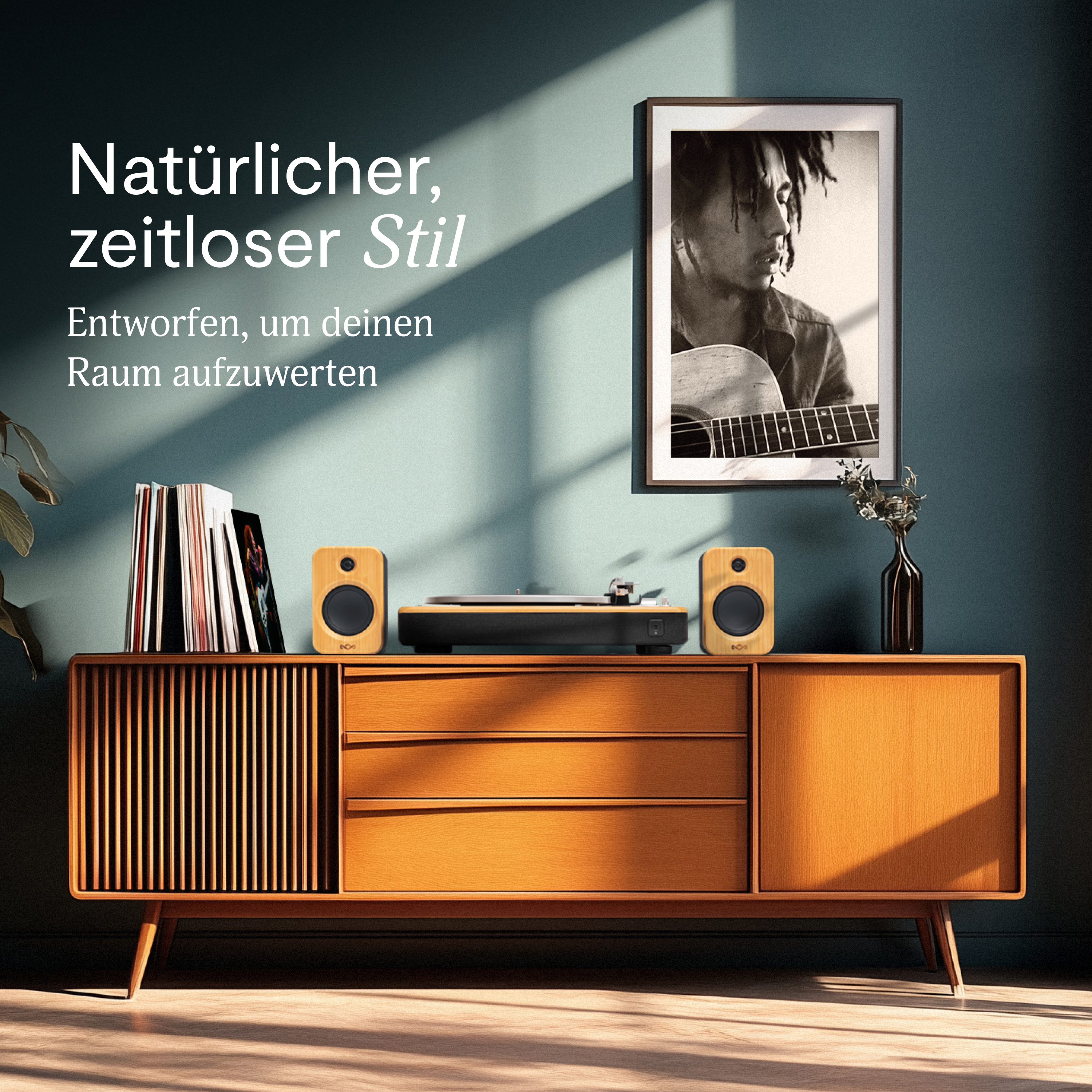Ein Mid-Century-Modern-Schrank mit Plattenspieler und Lautsprechern. Ein gerahmtes Bild hängt darüber. Text auf Deutsch sichtbar.