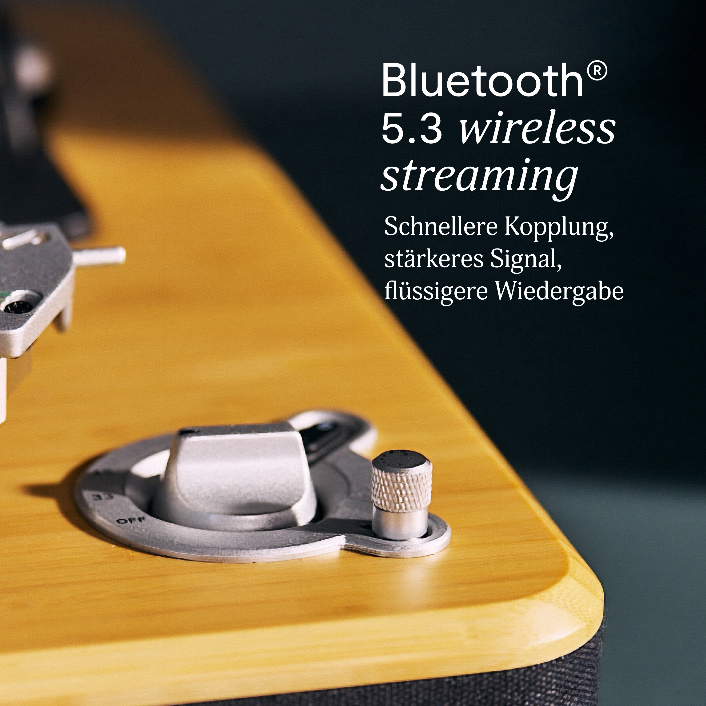 Nahaufnahme eines Plattenspielers mit Holzoberfläche. Text sagt Bluetooth 5.3 Wireless-Streaming, schnelleres Pairing, starkeres Signal.