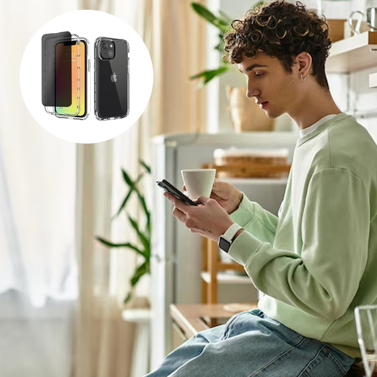 Ein Mann schaut auf sein Handy, während er eine Tasse hält. Im Hintergrund sind zwei Handyhüllen. Der Mann trägt einen grünen Pullover und Jeans.
