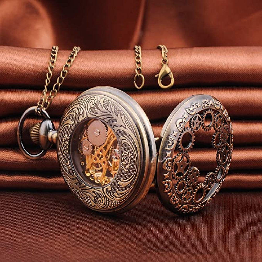 Eine bronzefarbene Taschenuhr mit offenem Zifferblatt, die Zahnräder zeigt. Sie liegt auf einem braunen Stoff, Kette und Verschluss sichtbar.
