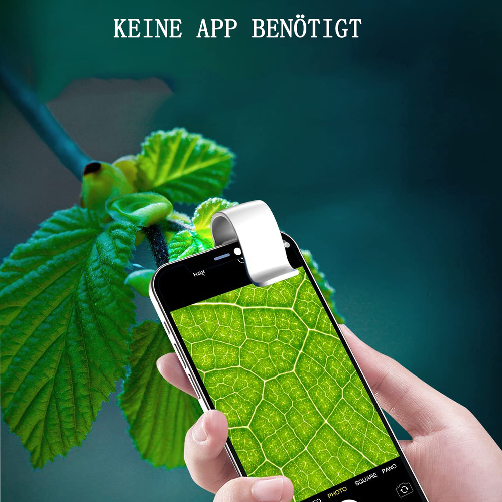 Eine Hand hält ein Telefon, auf dem ein Blatt fokussiert ist. Ein weißer Clip ist befestigt. Grüne Blätter sind im Hintergrund. Text: 'KEINE APP BENÖTIGT'.