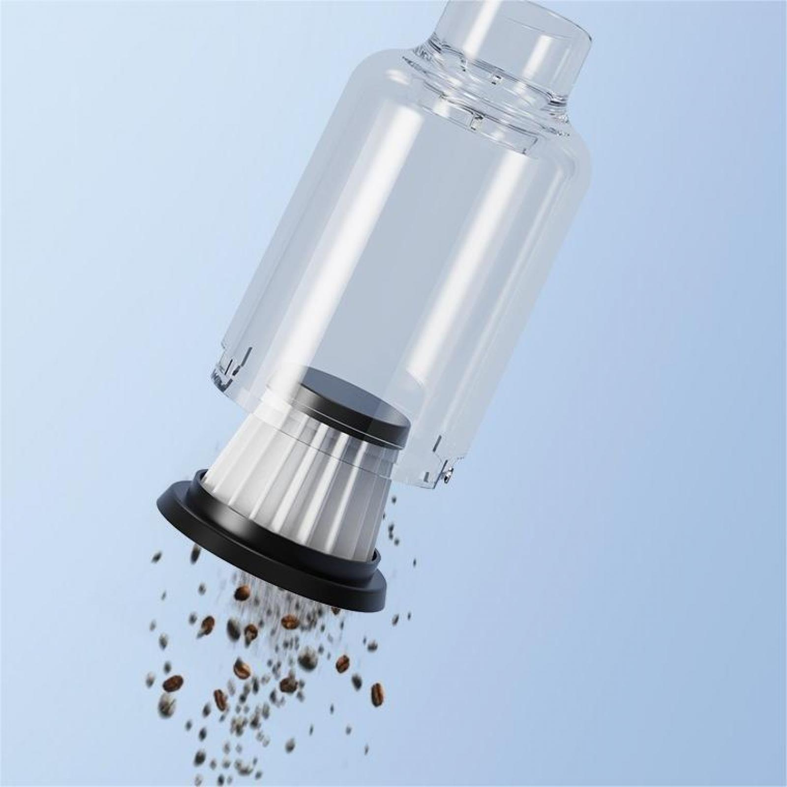 Transparenter Behälter mit Filter, Kaffeebohnen fallen. Hellblauer Hintergrund.