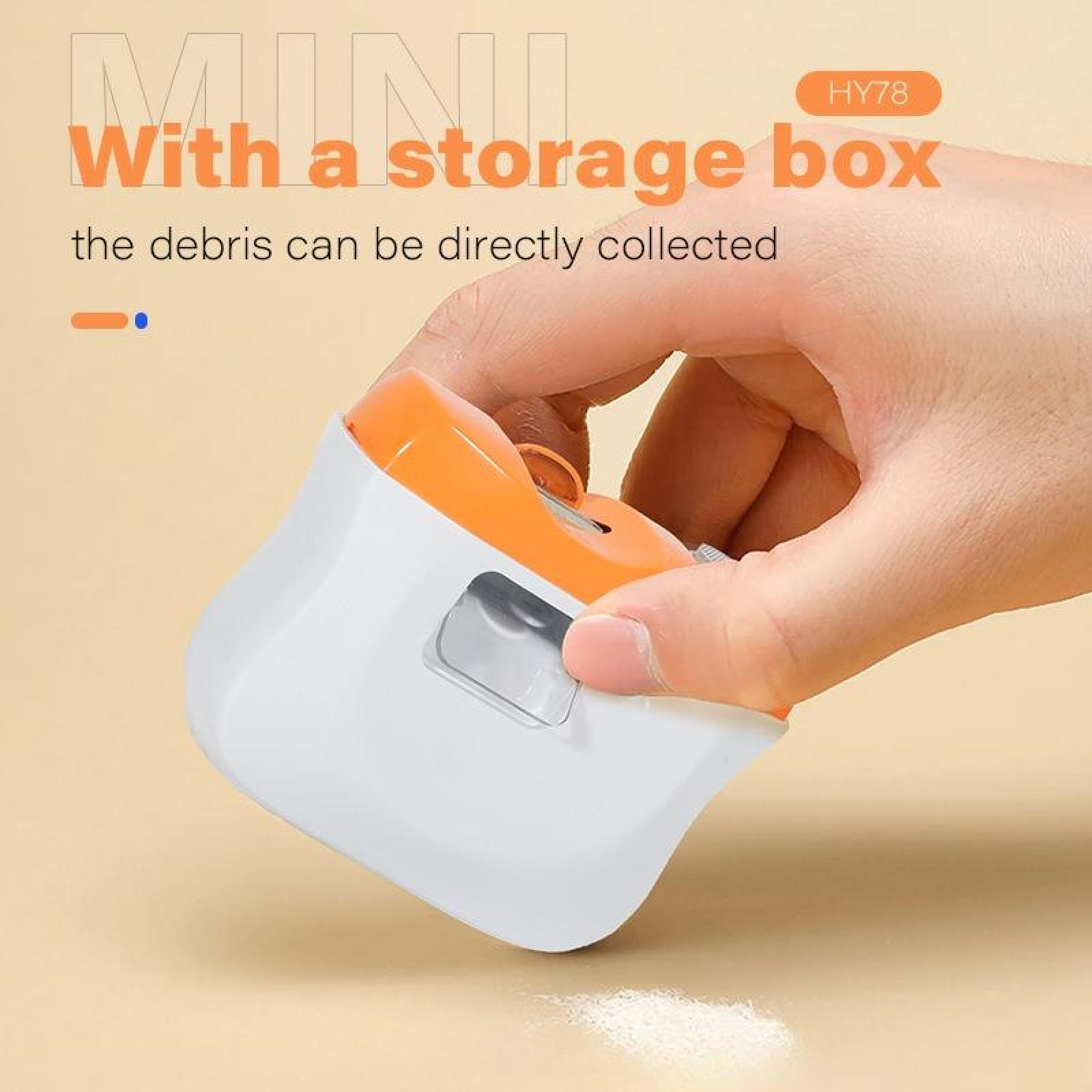 Eine Hand hält einen weiß-orangenen Mini-Staubsauger. Text sagt 'Mit einer Aufbewahrungsbox'. Schmutz liegt auf einer Oberfläche.