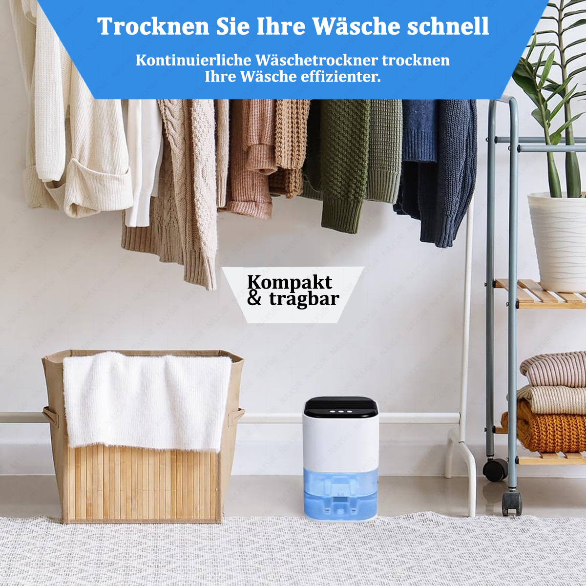 Kleidung hängt auf einem Gestell. Ein Luftentfeuchter steht darunter. Ein Korb mit einem Handtuch befindet sich im Vordergrund.