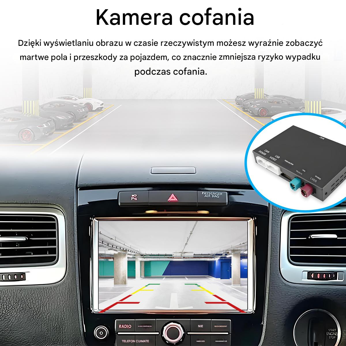 Wnętrze samochodu z wyświetlaczem pokazującym widok parkingu. Czarne pudełko z kolorowymi złączami w rogu.