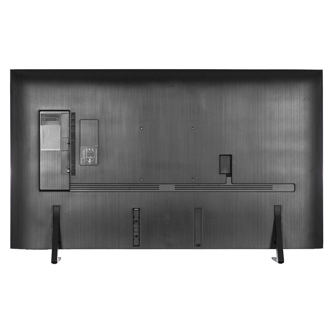 Rear view of a large, black TV. It has ports, a stand, and a textured surface. The TV is on a white background.