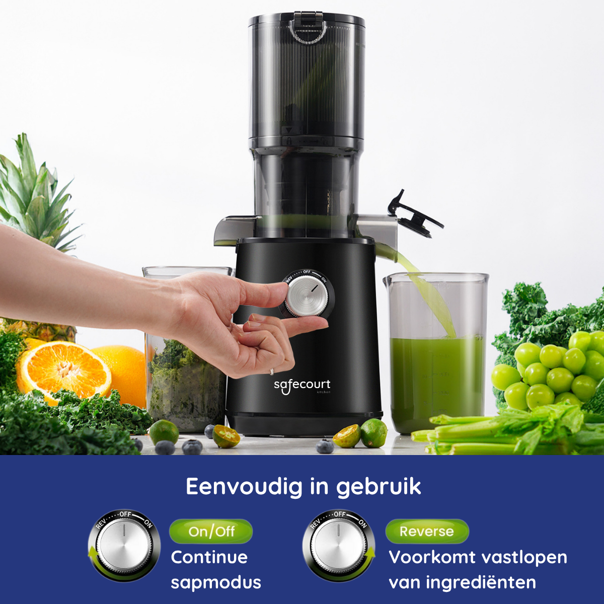 A black juicer with a hand turning the dial. Green juice flows into a glass. Fruits and vegetables surround the juicer.