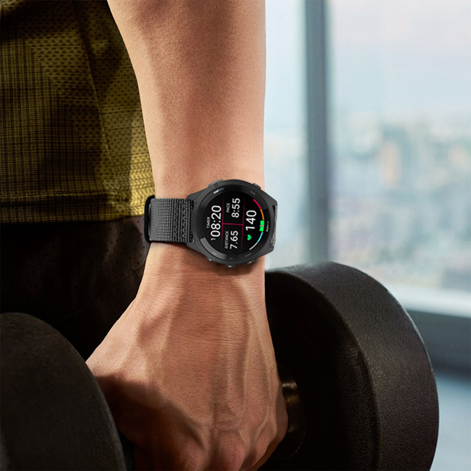 Osoba nosząca smartwatch, trzymająca hantle. Zegarek wyświetla czas i statystyki. Skup się na nadgarstku i hantlach.