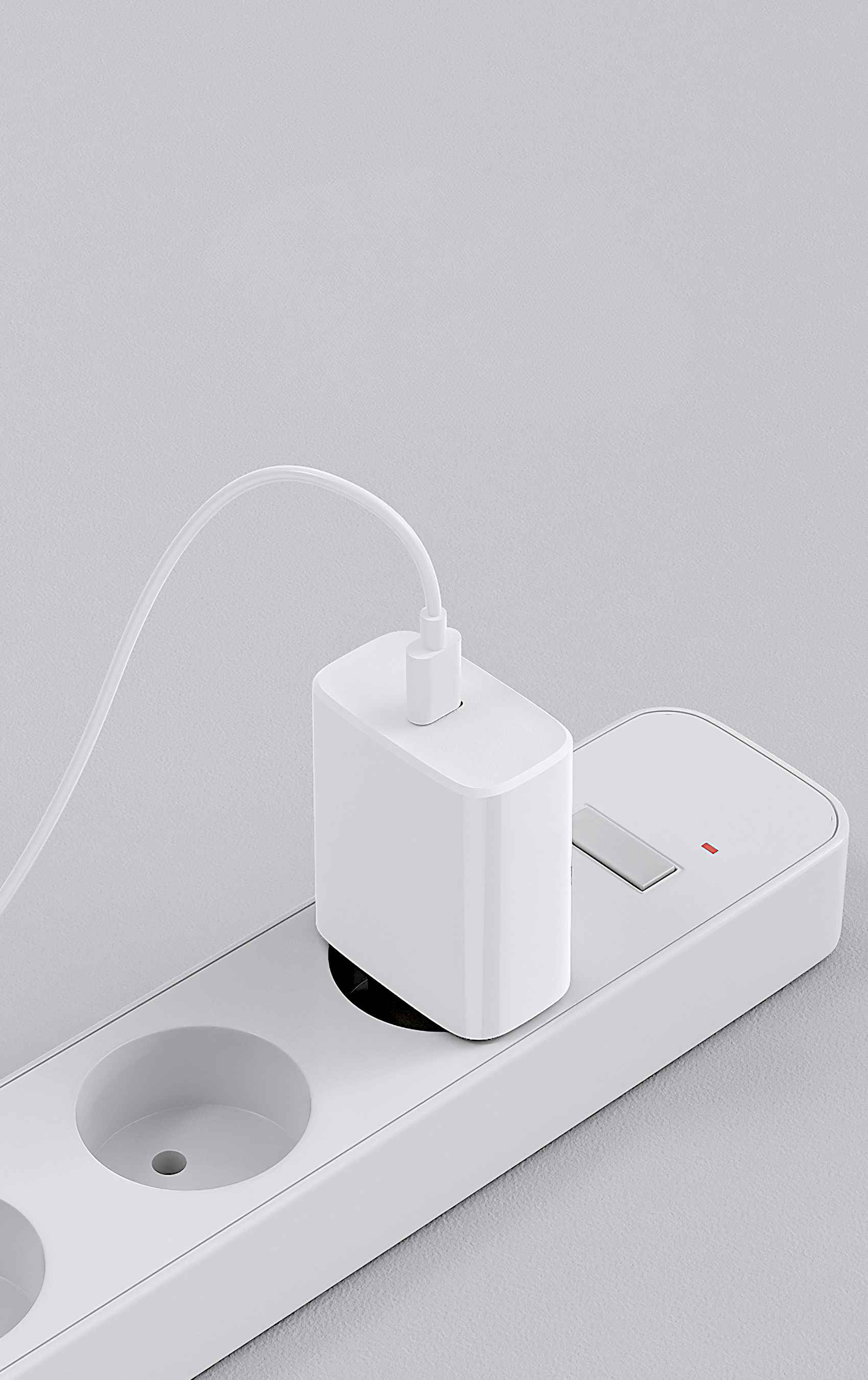 Ein weißer Netzadapter ist in eine weiße Steckdosenleiste eingesteckt. Ein weißes Kabel verbindet Adapter und Leiste.