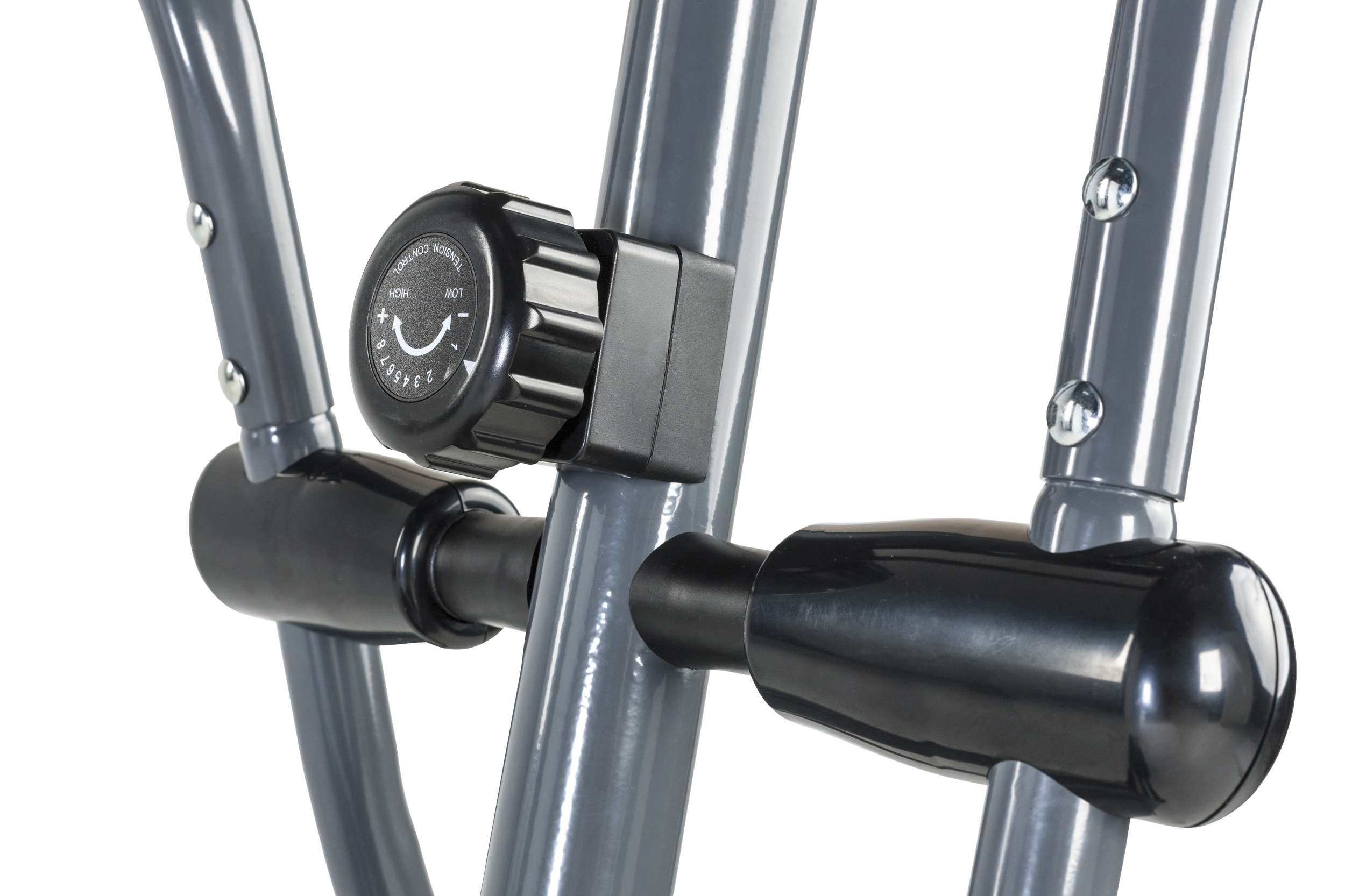 Close-up van trainingsapparatuur. Een zwarte spanningsknop is zichtbaar, tegen een grijs metalen frame.