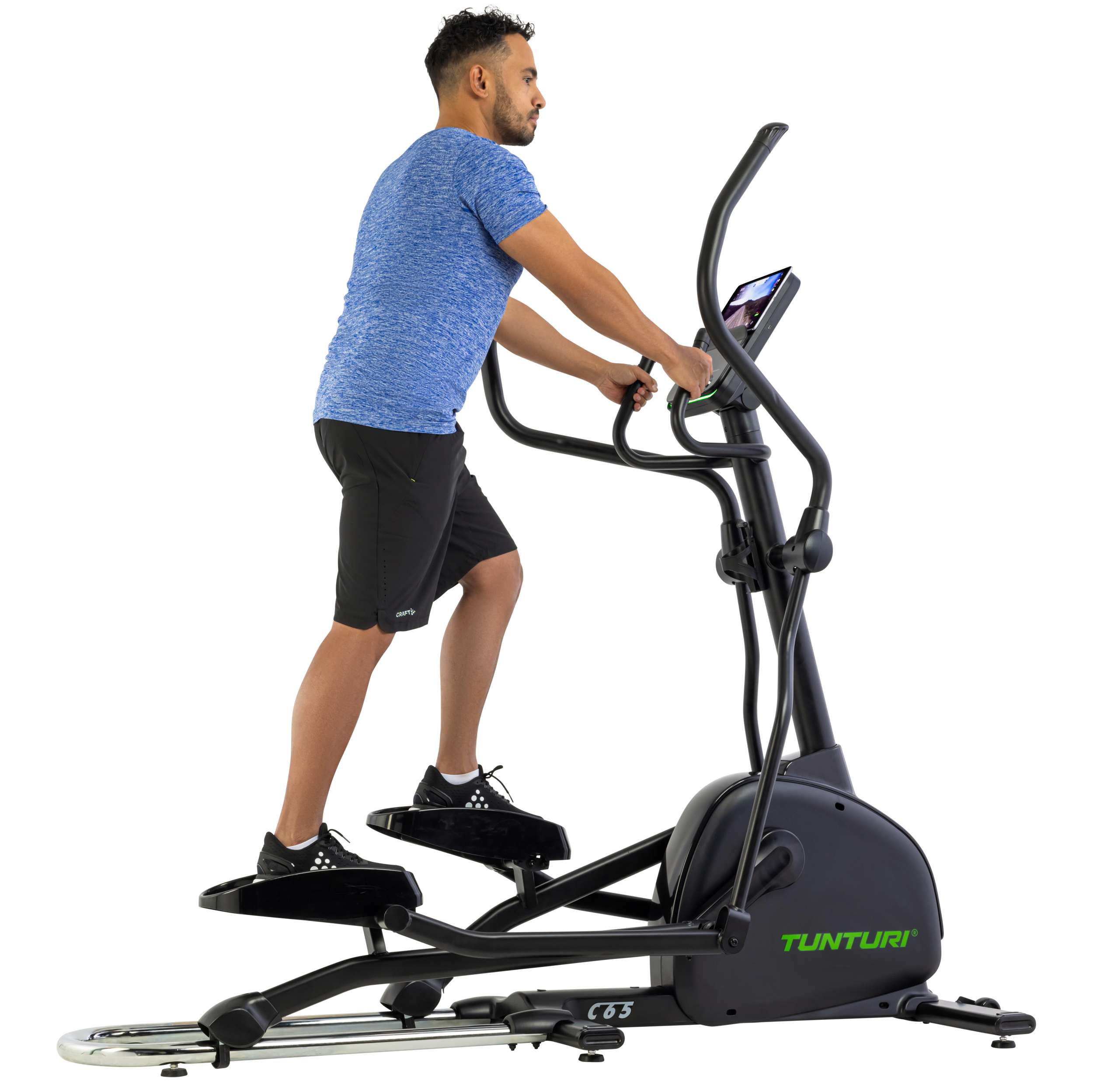 Een man in een blauw shirt en een zwarte korte broek gebruikt een zwarte Tunturi crosstrainer. Hij sport binnen.