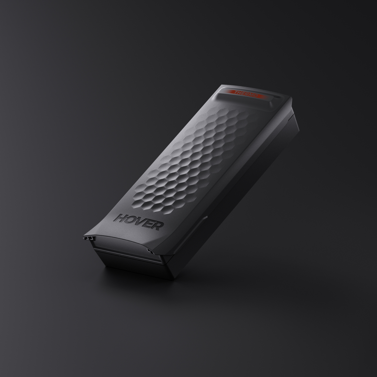 Czarne urządzenie z wzorem plastra miodu i napisem 'HOVER'. Na górze napis 'THERMO'. Tło jest ciemnoszare.