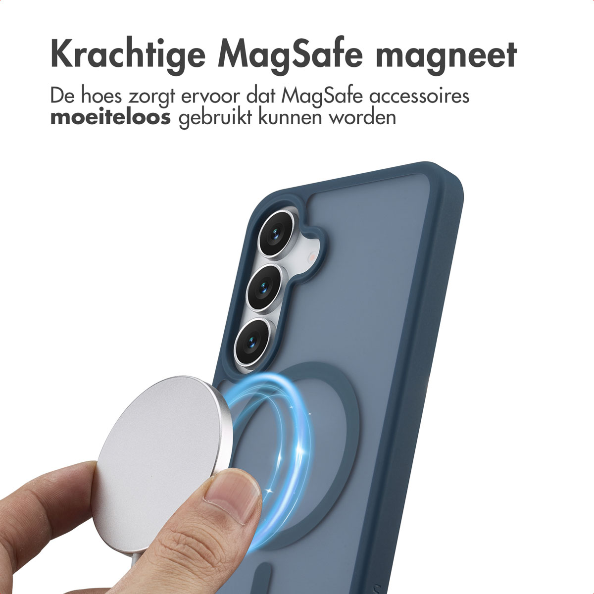 Een hand houdt een zilveren MagSafe-magneet vast bij een telefoon in een blauwe hoes. De telefoon heeft drie cameralenzen.
