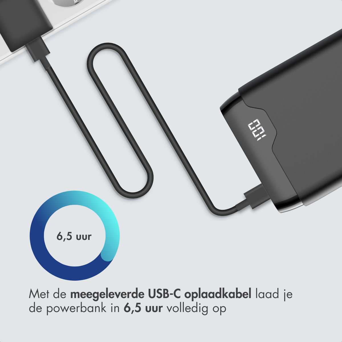 Une batterie externe noire se recharge via un câble USB-C. Elle affiche 100% sur l'écran. Un graphique indique 6,5 heures de temps de charge.