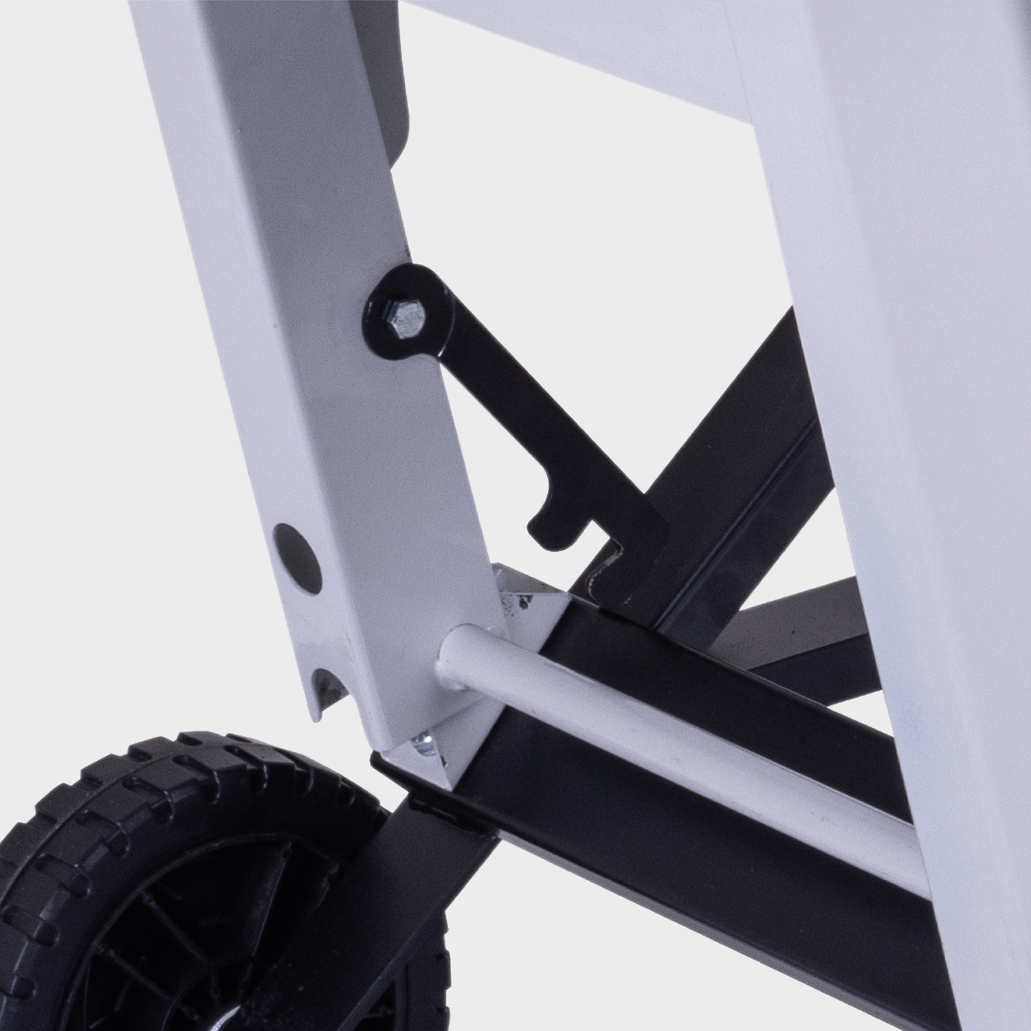 Close-up of a white and black wheeled cart.  A black wheel is in the bottom left, with a black and white frame.