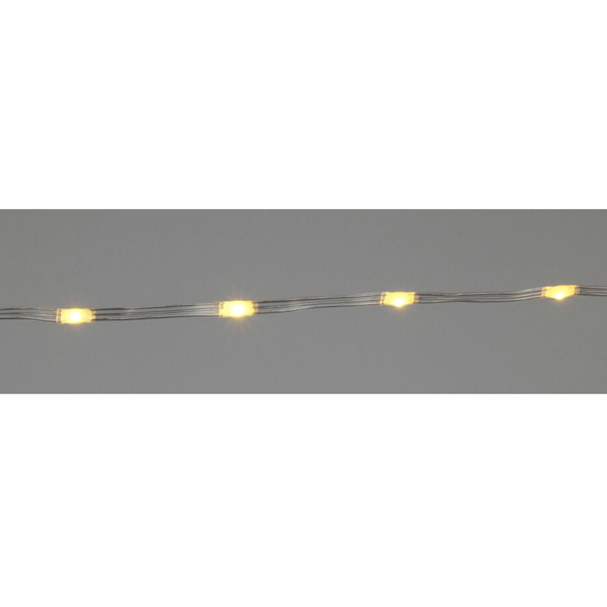 Primer plano de luces de cadena. Cada luz brilla en amarillo. El fondo es un gris suave.