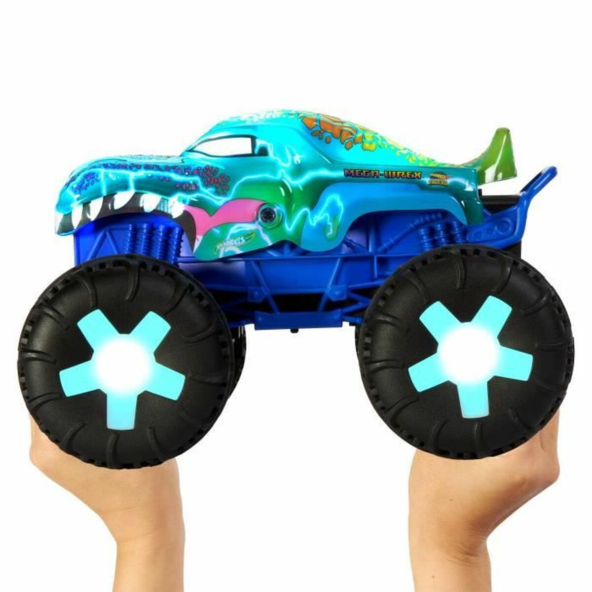 Un camión monstruo azul de juguete con diseño de dinosaurio. Las ruedas tienen luces brillantes azules en forma de estrella. Sostenido por dos manos sobre fondo blanco.