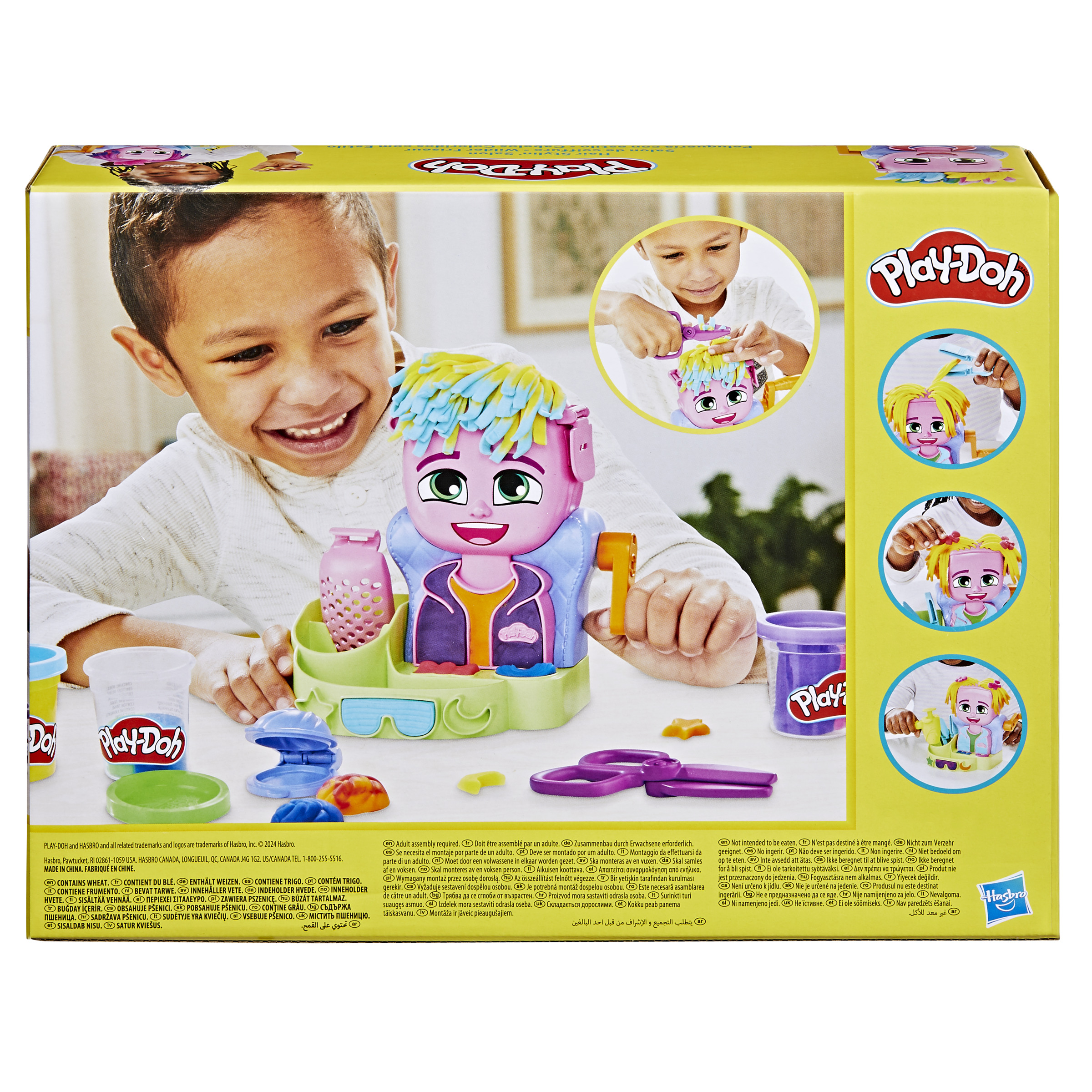 Un niño sonríe jugando con un set de peinado Play-Doh, con la caja en el fondo.