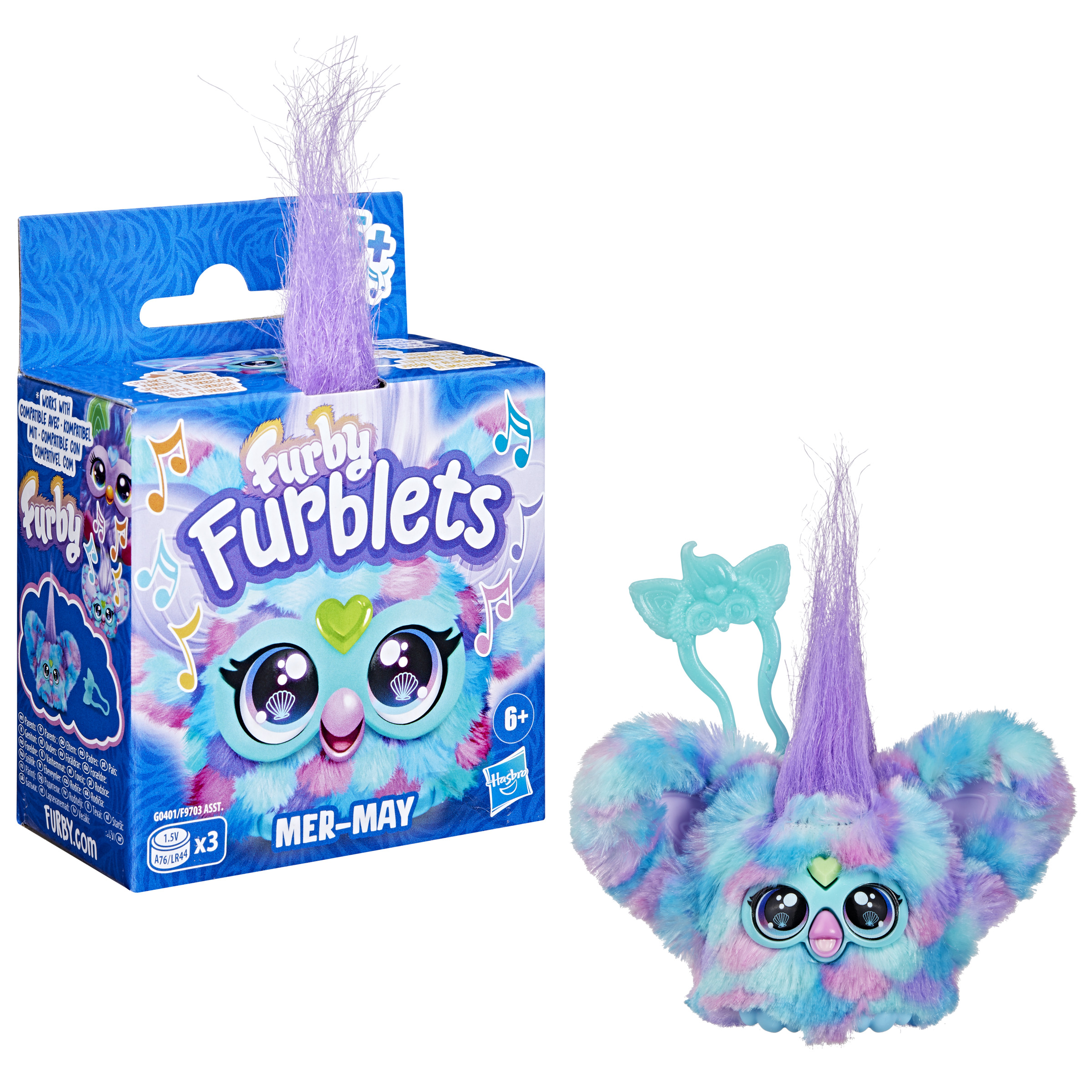 Un juguete Furby Furblets, edición Mer-May, en una caja. Es un peluche con pelo azul, morado y rosa.