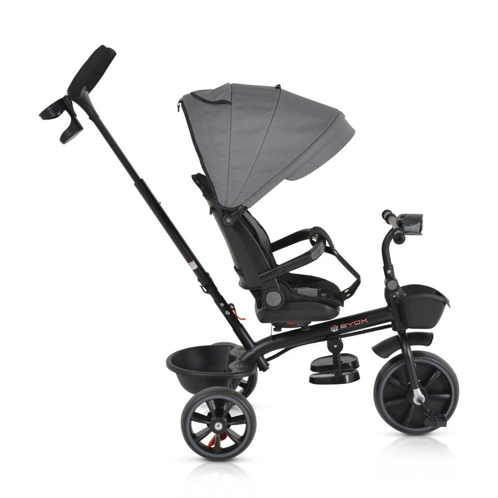 Un triciclo negro con capota gris. Tiene manillar para padres, asiento, reposapiés y cestas de almacenamiento. Las ruedas son negras.