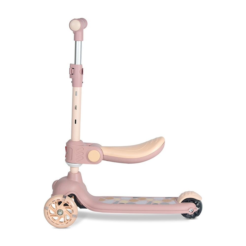 Un patinete rosa y beige con tres ruedas, asiento y manillar ajustable. La plataforma tiene un diseño estampado.