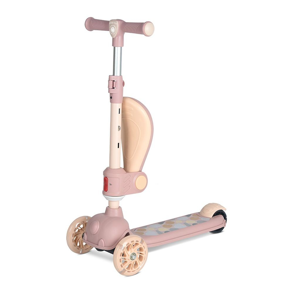 Un patinete rosa y beige con tres ruedas. Tiene manillar, plataforma y estructura tipo asiento para apoyo.