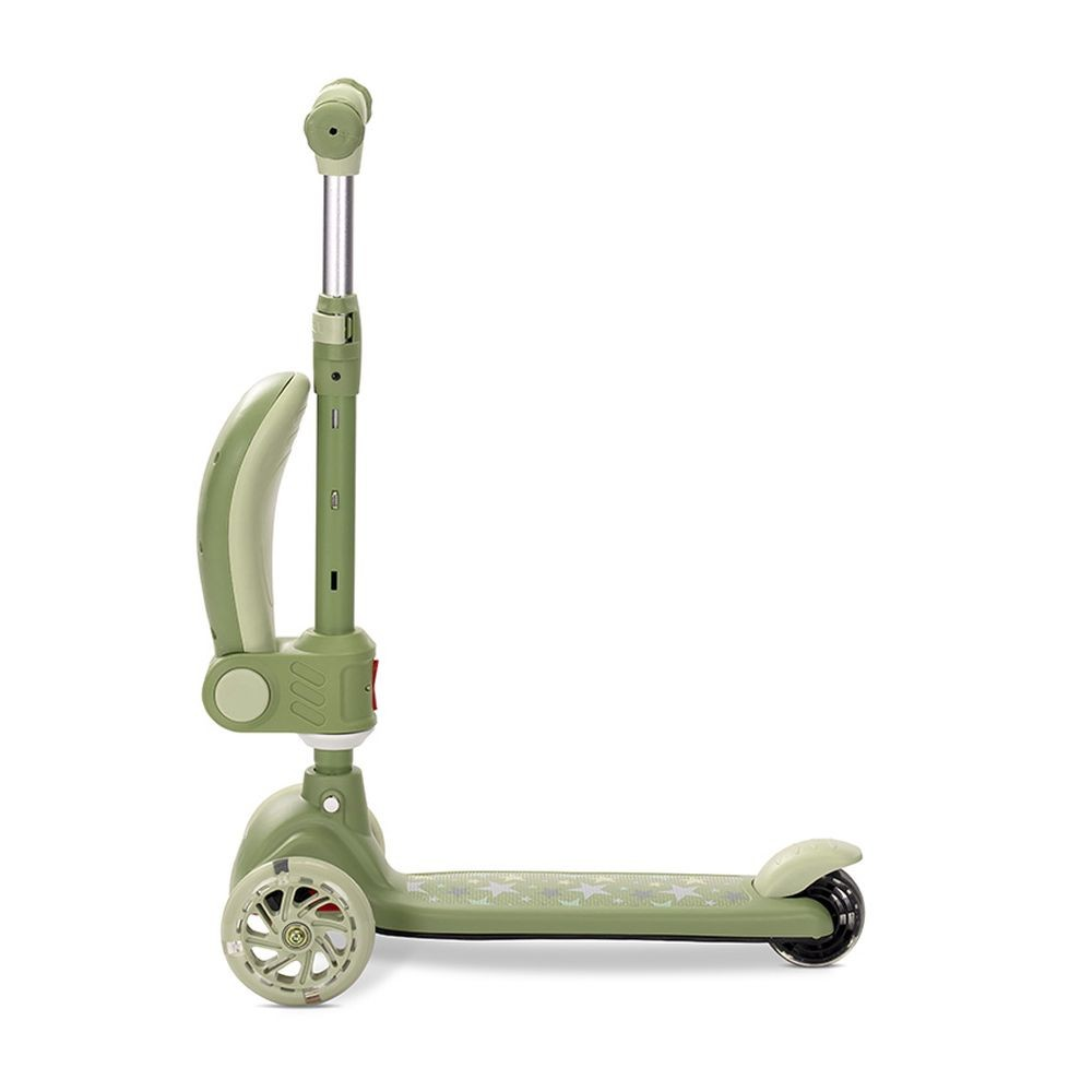 Un patinete verde con tres ruedas. Tiene un manillar, una plataforma para los pies y un freno trasero. El fondo es blanco.