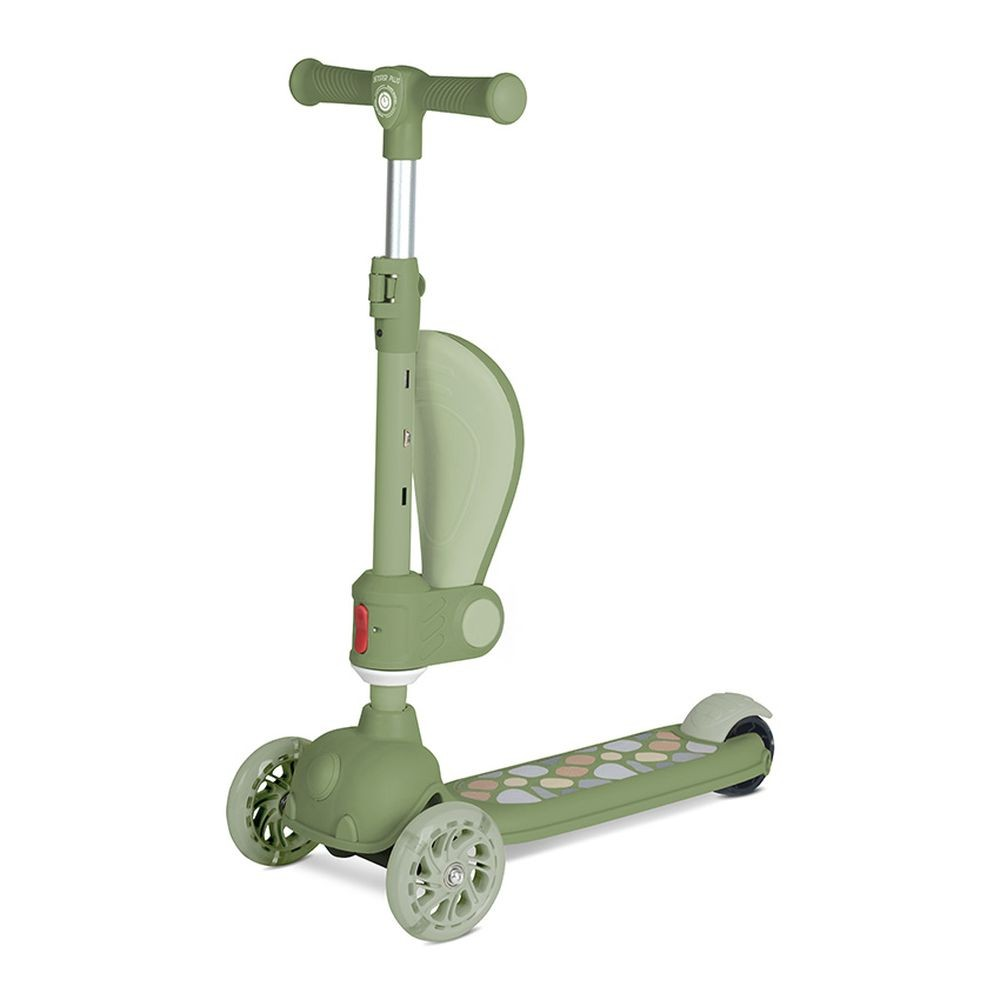 Un patinete verde con tres ruedas. Tiene manillar, plataforma para los pies con patrones de colores y soporte trasero curvo.