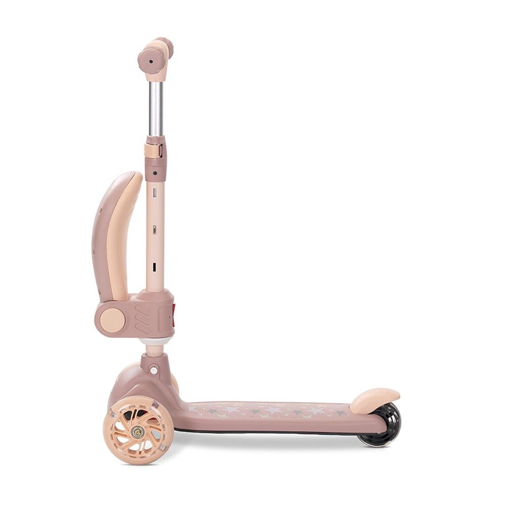 Un patinete beige y rosa. Tiene manillar, reposapiés con estrellas, tres ruedas y un asa curva para agarrar.