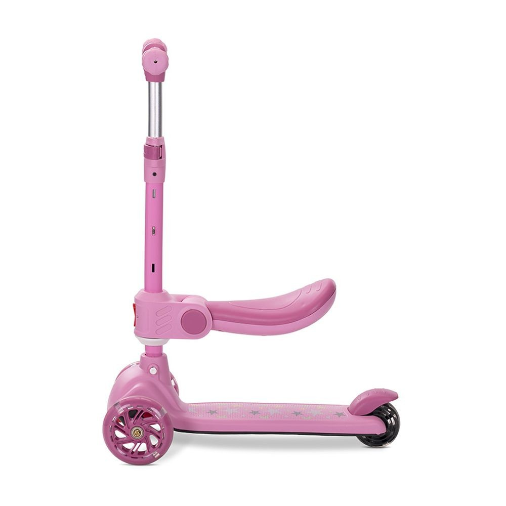 Un patinete rosa con tres ruedas, un asiento y un manillar. La plataforma tiene diseños de estrellas. Sobre un fondo blanco.