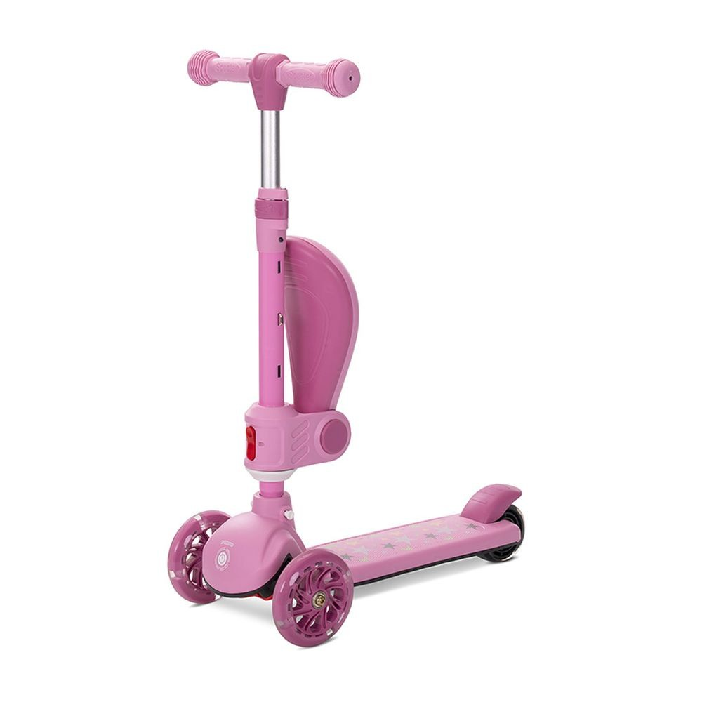 Un patinete rosa con tres ruedas. Tiene manillar, plataforma y asiento. Hay estrellas en la plataforma.