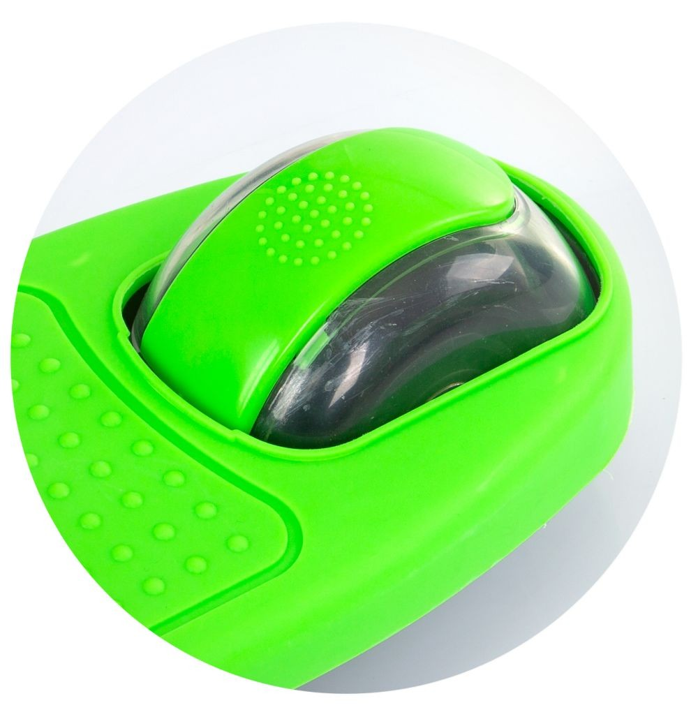 Primer plano de un rodillo de ejercicio verde con un rodillo transparente y negro en el interior. La base tiene pequeños bultos redondeados. El fondo es blanco.