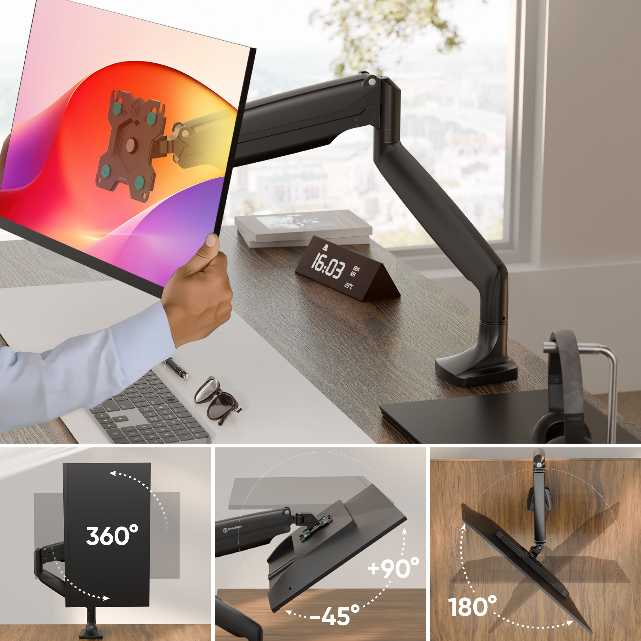 Monitor jest trzymany przez rękę. Obok znajduje się mocowanie do biurka. Na biurku znajdują się również zegar i słuchawki.