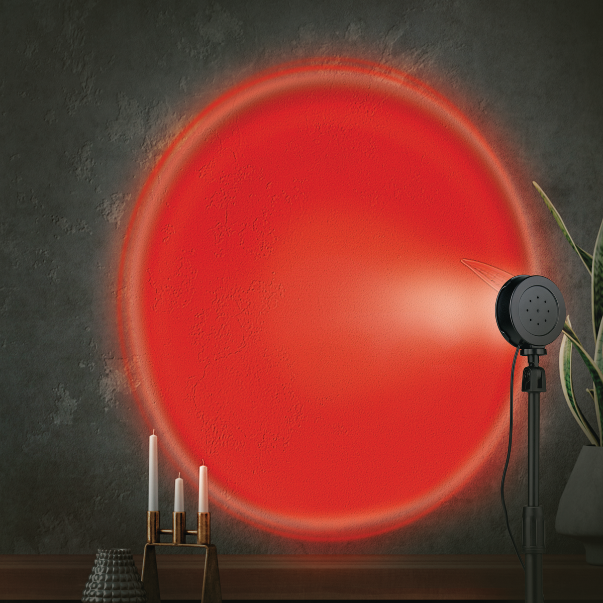 Een rode cirkel wordt geprojecteerd op een donkere, getextureerde muur. Een zwarte lamp, kaarsen en een plant zijn in de scène.