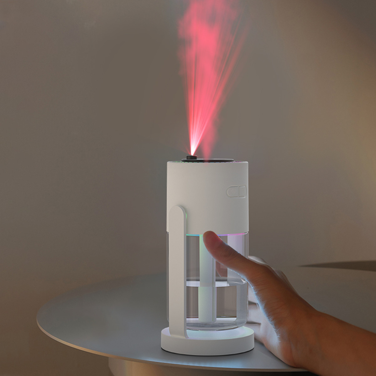 Ein weißer Luftbefeuchter mit rotem Lichtstrahl steht auf einem Tisch. Eine Hand berührt das Gerät. Der Hintergrund ist grau.
