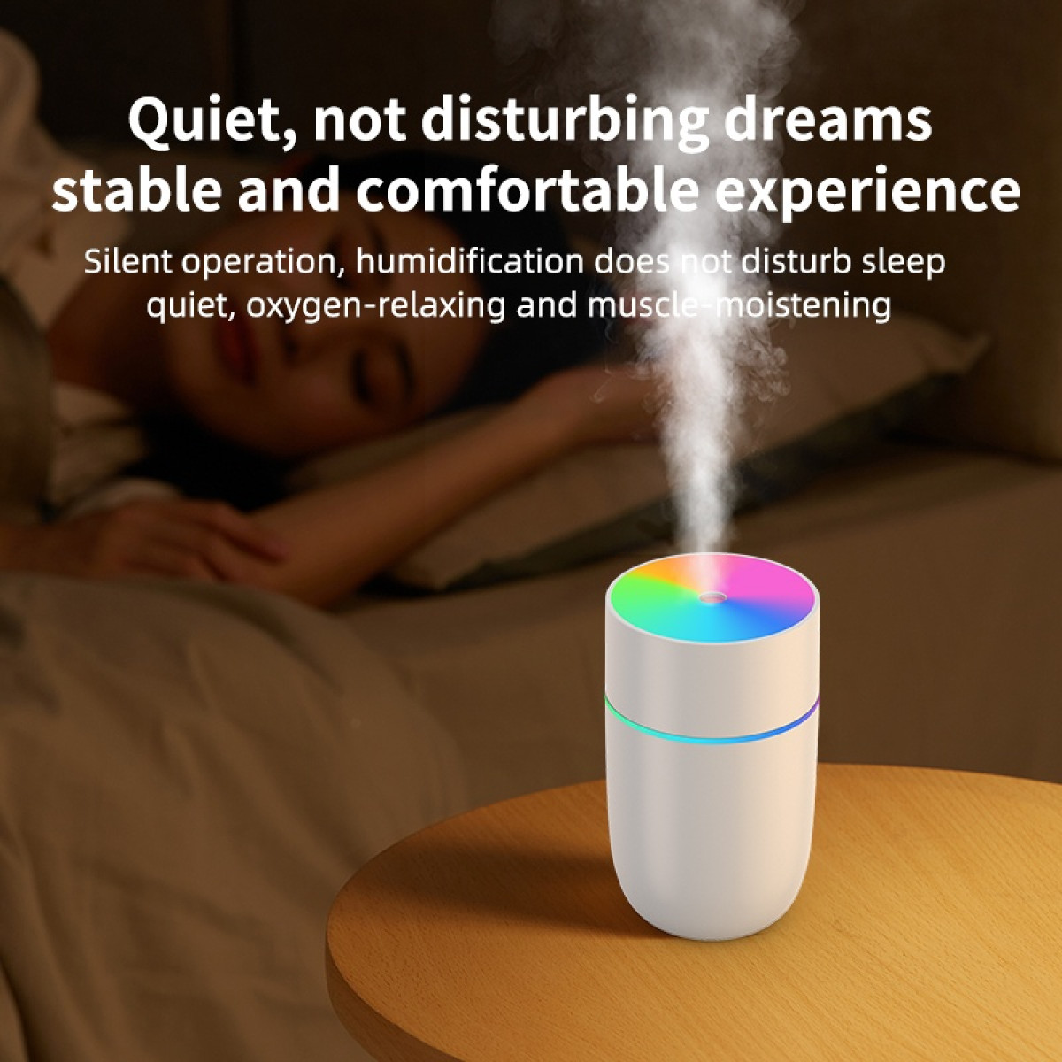 Ein weißer Luftbefeuchter auf einem Tisch mit einer schlafenden Person im Hintergrund. Der Luftbefeuchter stößt Nebel mit bunten Lichtern aus.